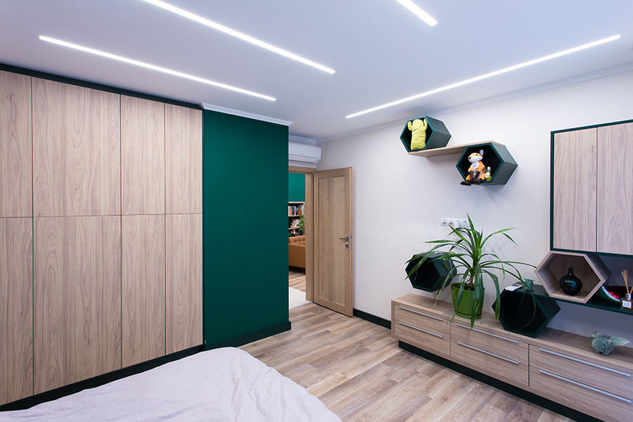 Társasházi lakás felújítása - hálószoba hatszög polcokkal, álmennyezeti fénycsatornás világítással